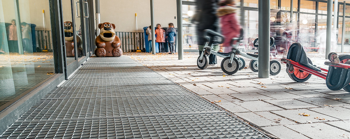 À l'entrée par laquelle les enfants pénètrent dans le bâtiment depuis la cour de récréation, le choix s'est porté sur le CleanBox, un paillasson modulaire drainant.