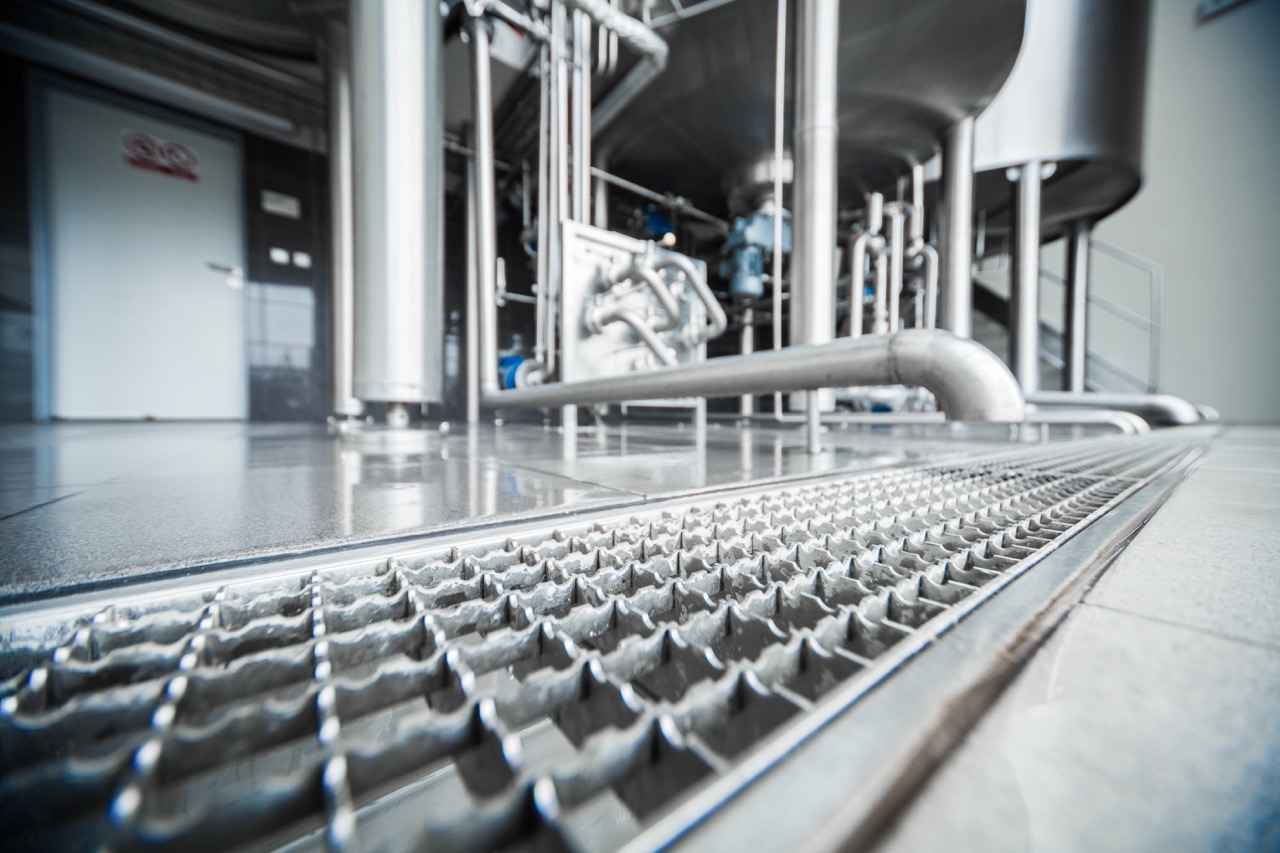 Caniveau ACO dans une zone de production avec grille caillebotis antidérapant