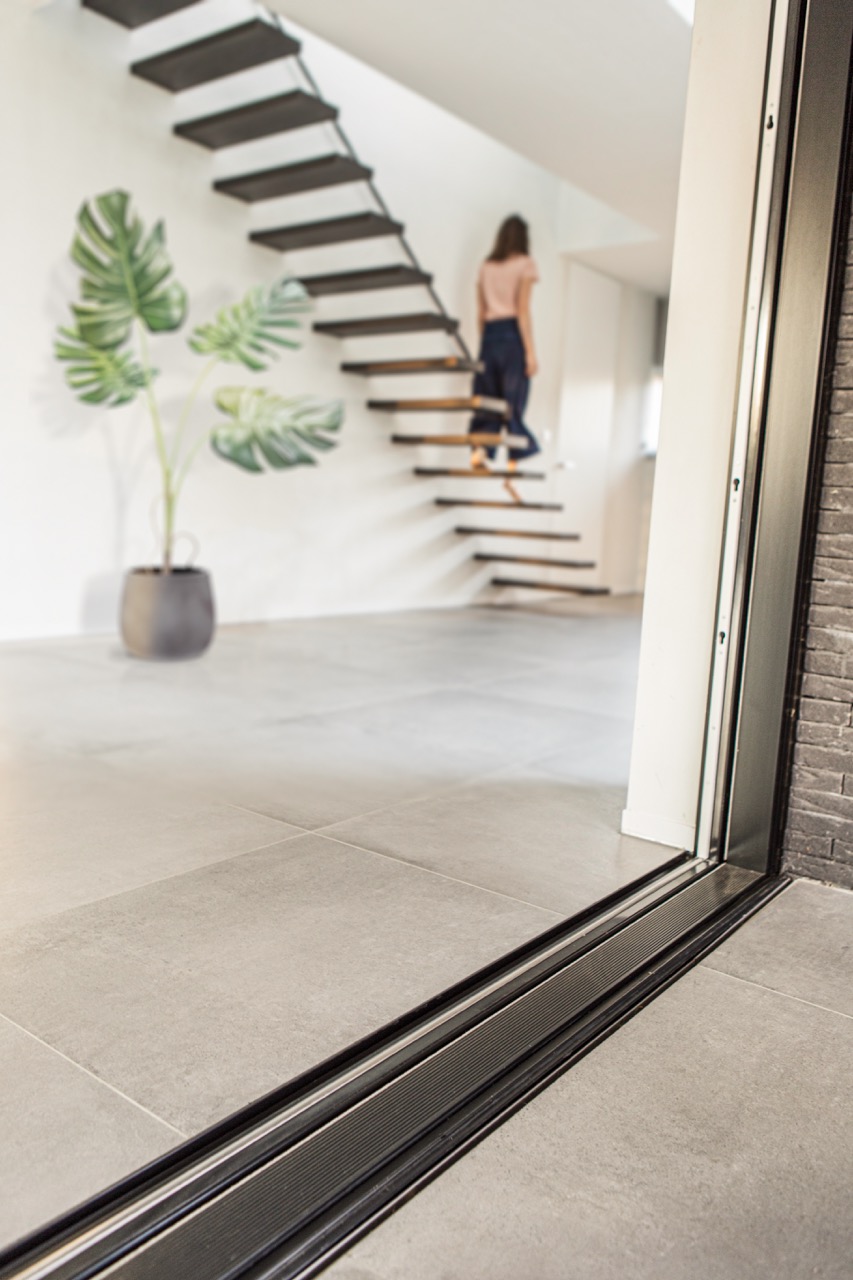 Passage sans seuil de l'extérieur à l'intérieur grâce au caniveau à fente ACO