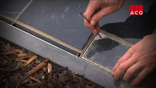 Comment nettoyer un drain à fente avec le tuyau d'arrosage ?